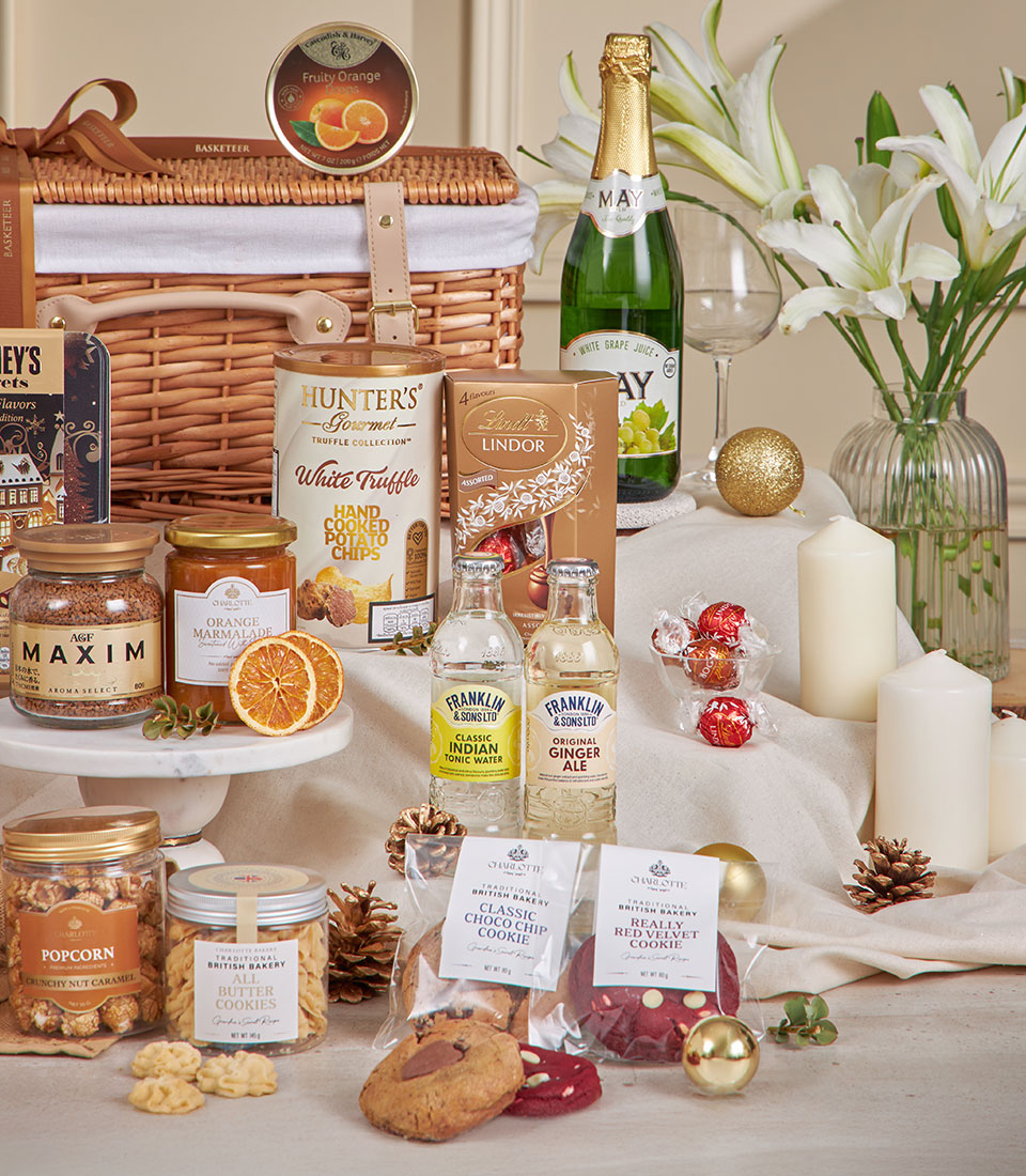 Luxury wicker hamper with gourmet chocolates, preserves, truffle chips, and festive decorations for New Year gifting