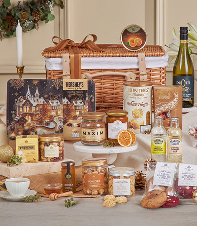 Premium golden gourmet hamper with wine, chocolates, coffee, and artisan treats in woven wicker basket