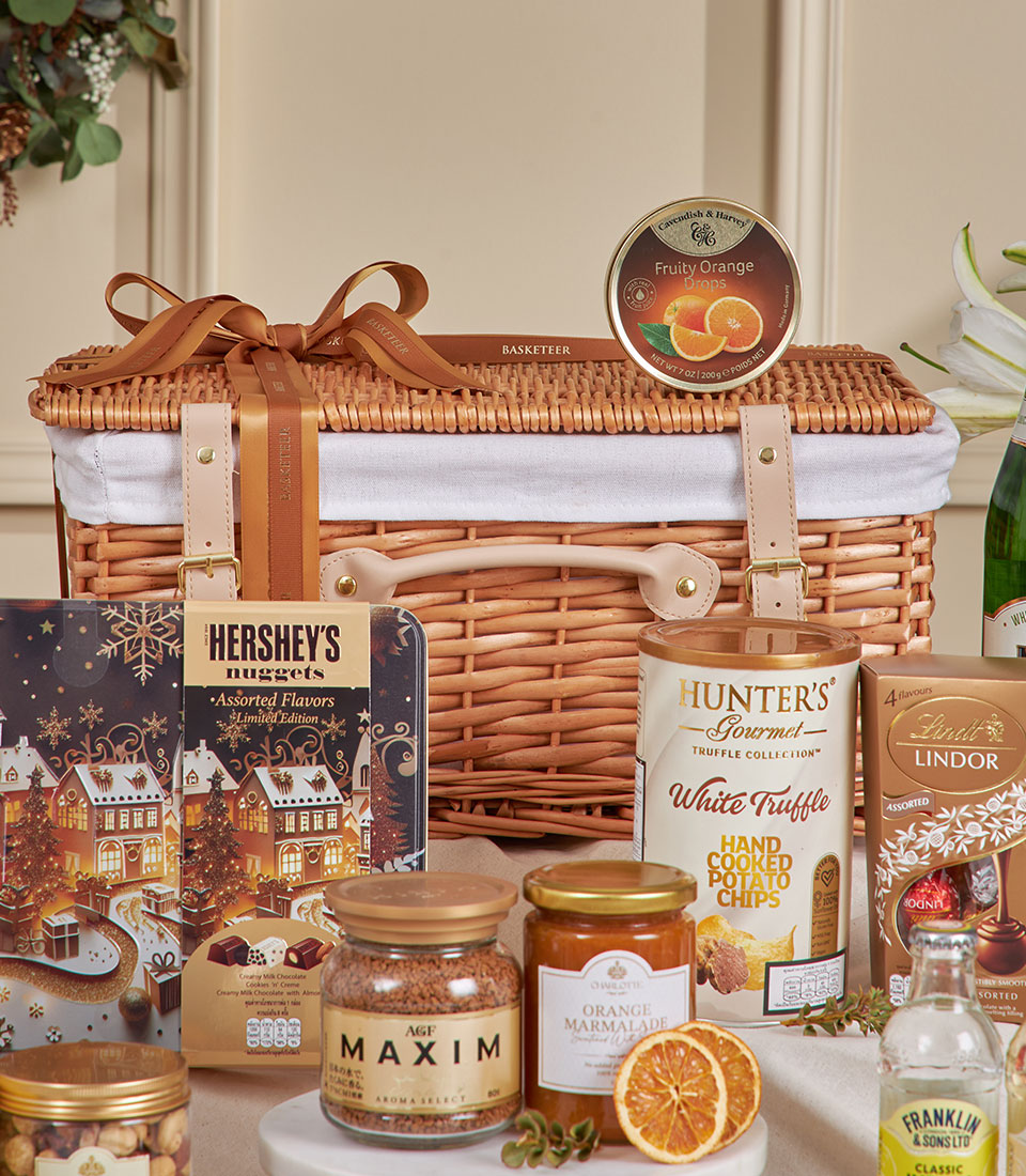 Premium golden gourmet hamper with artisan chocolates, truffle crisps, coffee, and marmalade in wicker basket, perfect for