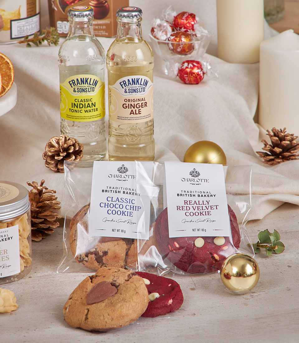 Premium golden gourmet hamper with artisan cookies, craft mixers, chocolates, and festive gold accents for New Year gifting