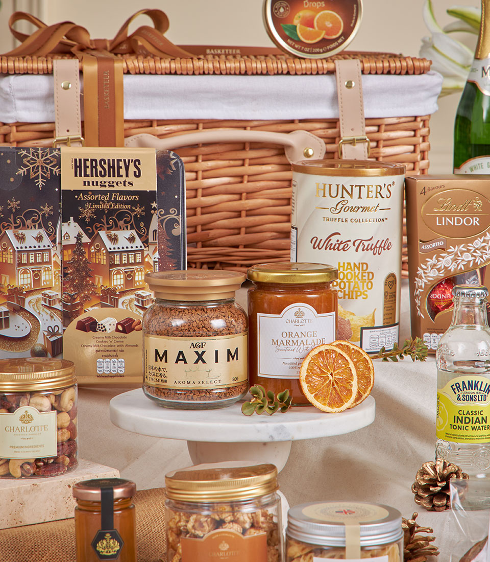 Premium golden gourmet hamper with chocolates, truffle chips, and artisan treats in woven wicker basket for New Year gifting