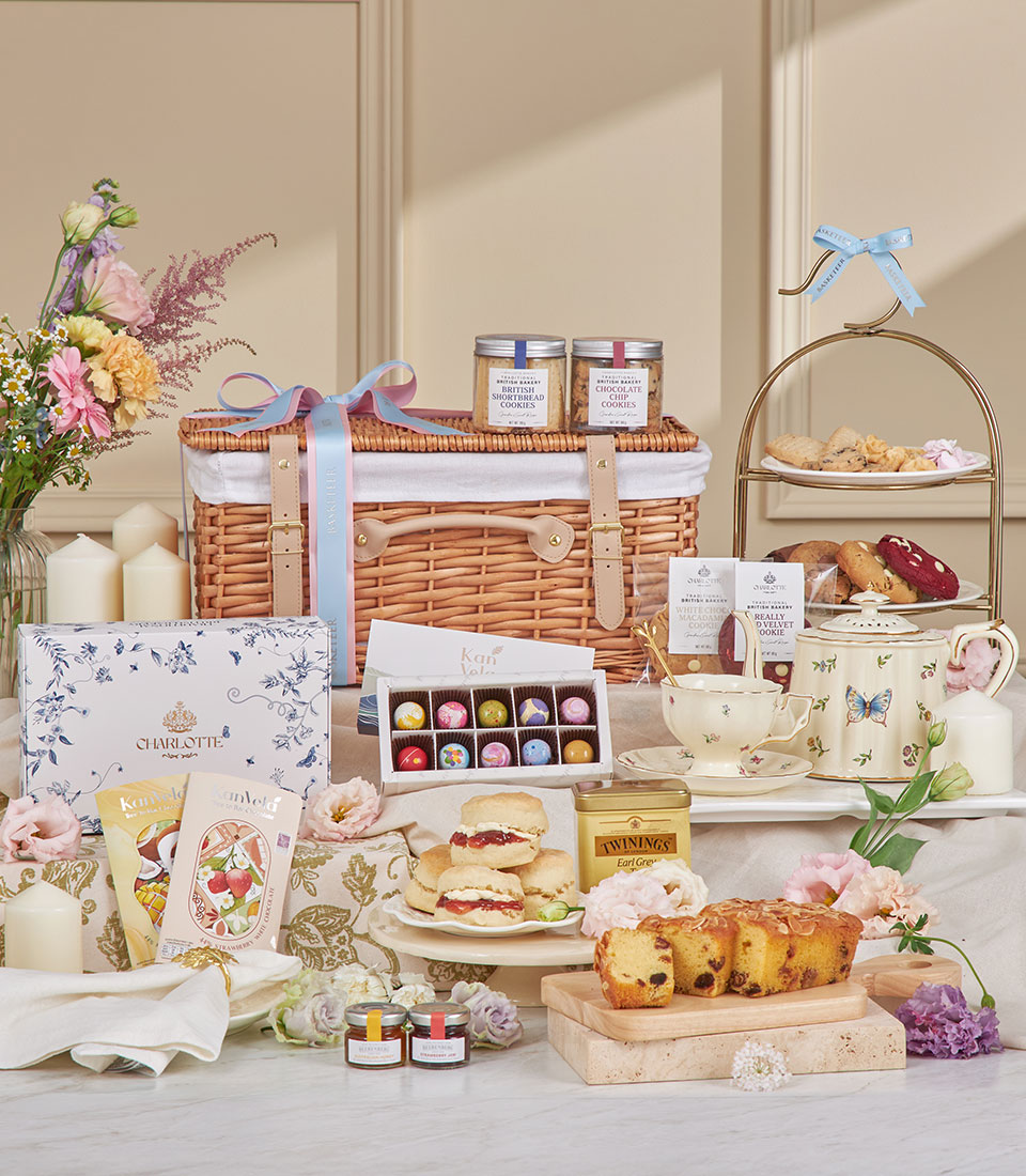 Luxury afternoon tea hamper with wicker basket, tiered pastry stand, Earl Grey tea, and fresh flowers