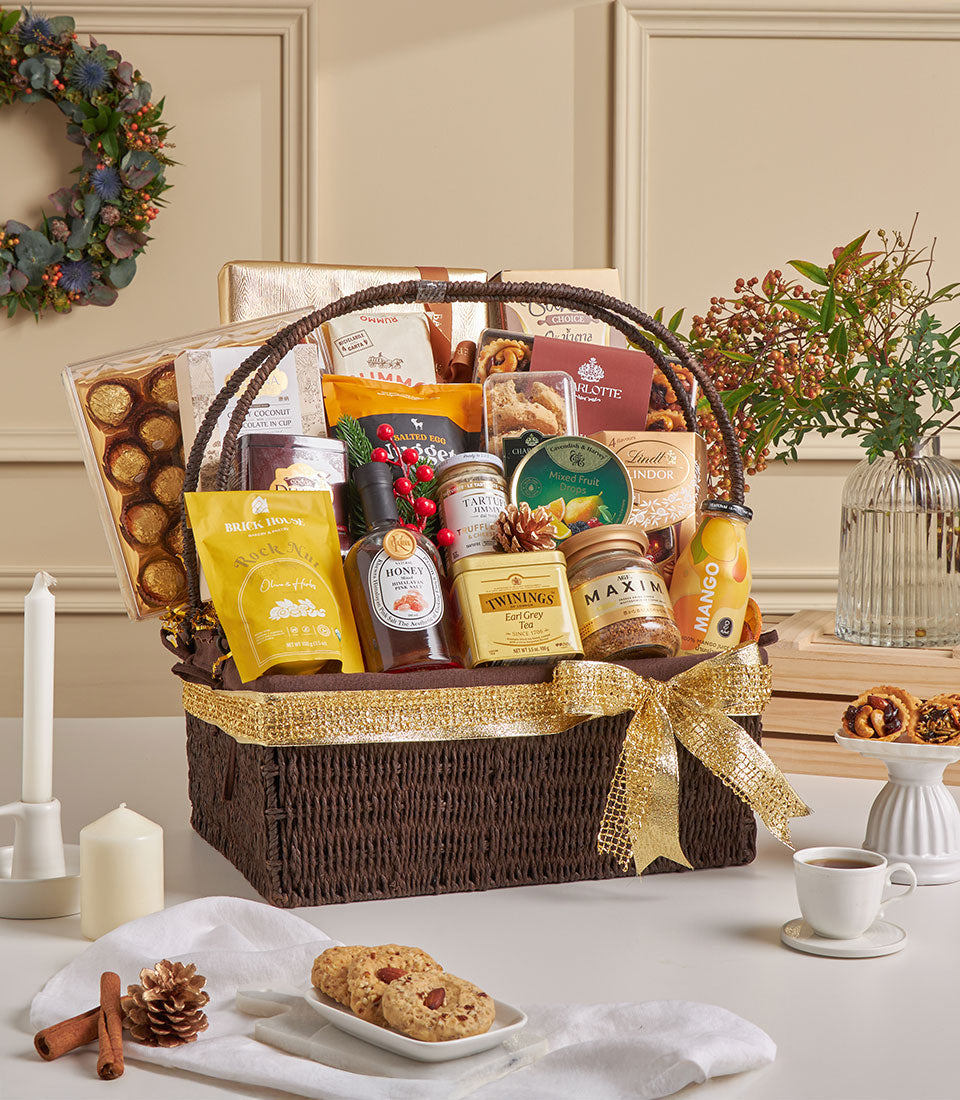 Dark woven gift basket with gourmet chocolates, honey, tea, and fine foods, tied with gold ribbon for New Year gifting