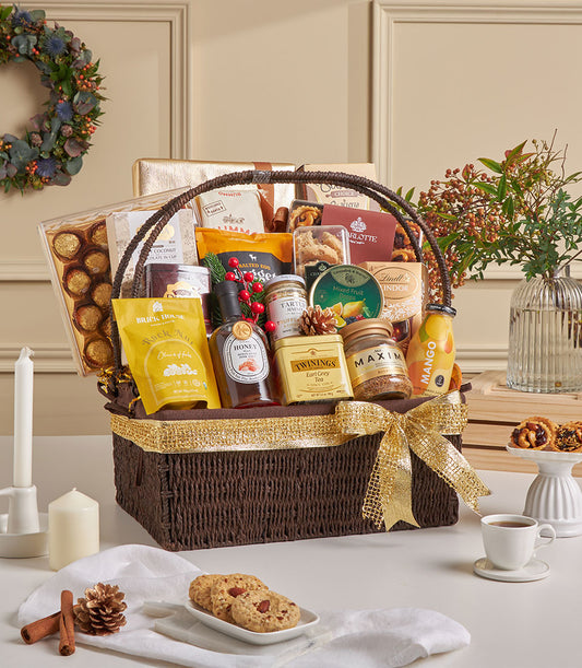 Dark woven gift basket with gourmet chocolates, honey, tea, and fine foods, tied with gold ribbon for New Year gifting