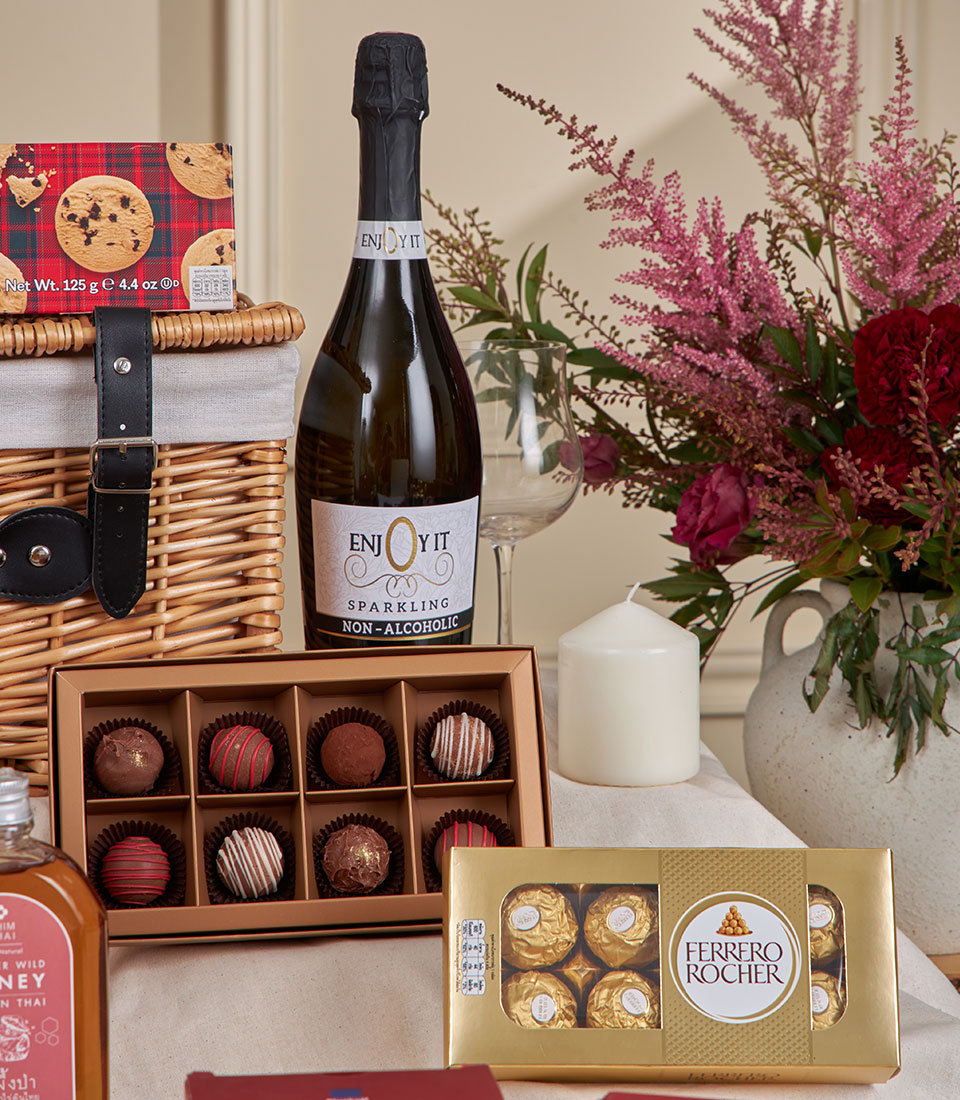 Luxury wicker picnic basket with sparkling beverages, artisan chocolates, and gourmet treats for New Year gifting