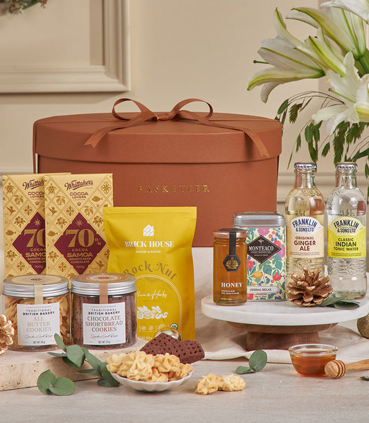 Burnt orange luxury gourmet gift basket with dark chocolate, cookies, honey, tea, and artisan beverages for New Year