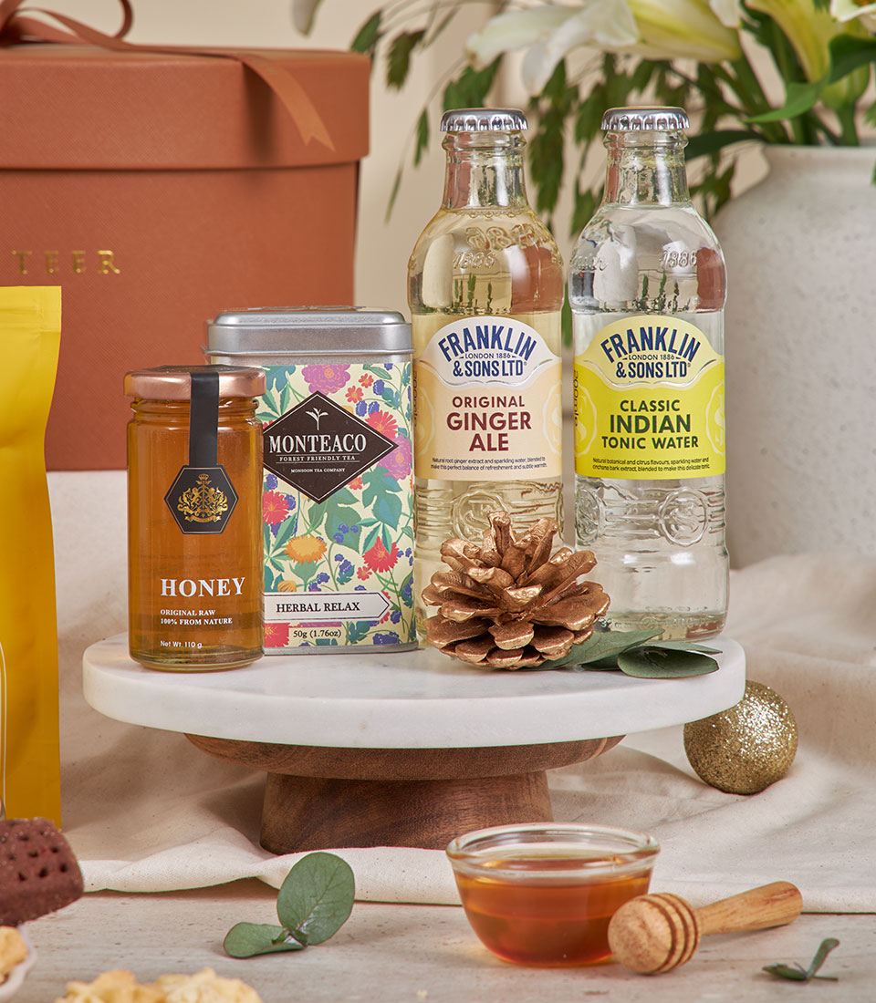 Brown luxury gourmet gift basket with honey, herbal tea, and artisan beverages for New Year celebrations