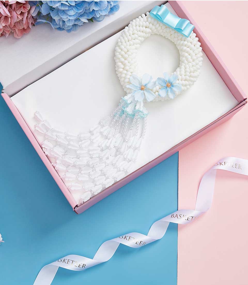 White floral garland with blue bow and beaded strands in luxury gift box for Mother's Day