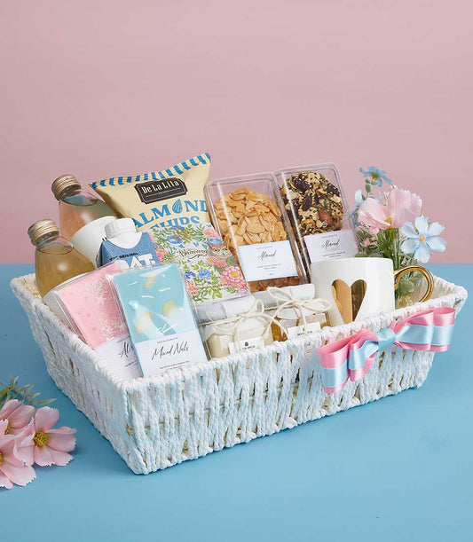 Luxury Mother's Day gift basket with gourmet treats, almonds, oats, and heart-motif mug in white woven design