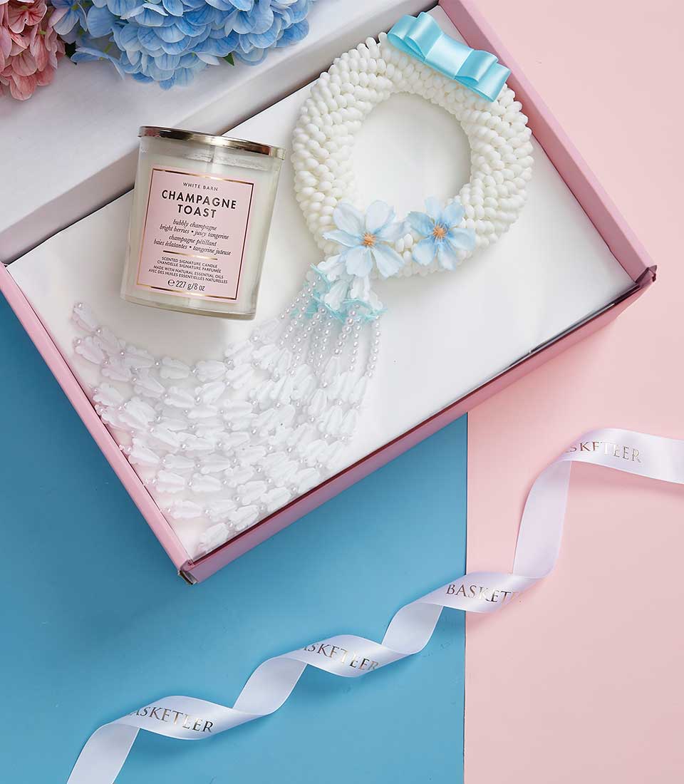 Mother's Day gift set with champagne toast candle and white beaded garland with blue flowers