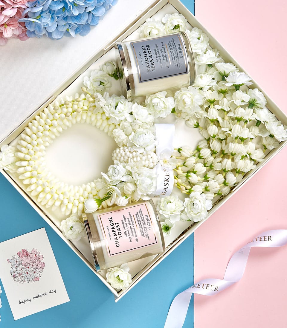 Curated Mother's Day gift set with scented candles, white floral garland, and greeting card in luxury white box