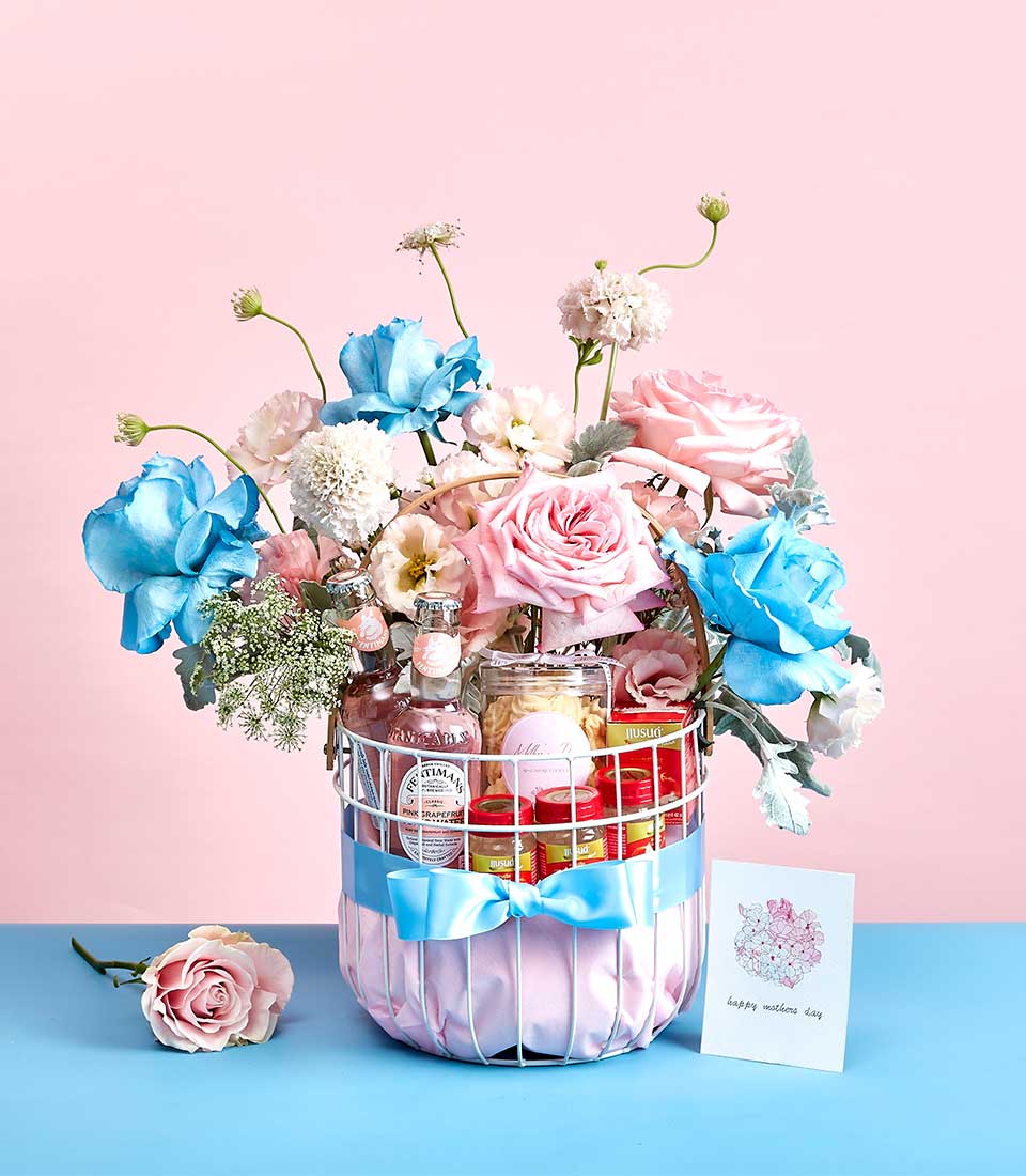 Luxury Mother's Day gift basket with bird's nest, pink grapefruit beverages, and pastel roses in white wire design