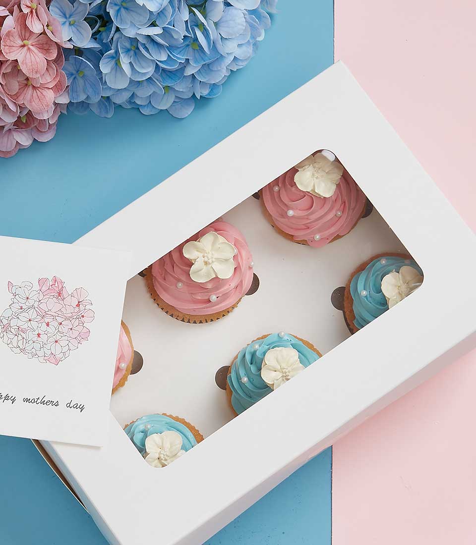 Luxury cupcake gift box with pink and blue frosting, white pearl toppings, and floral card for Mother's Day
