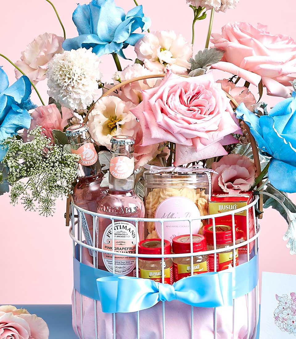 Luxury bird's nest gift basket with pink beverages, gourmet cookies, and fresh roses for Mother's Day