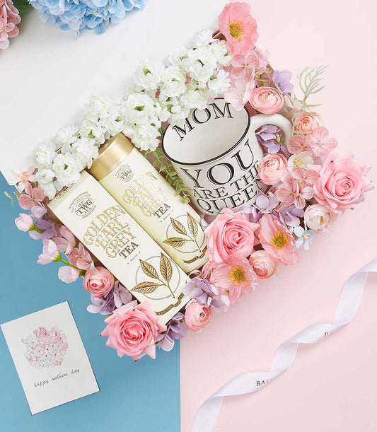 Luxurious Mother's Day gift set with Golden Earl Grey tea, ceramic queen mug, and silk flowers in white, pink, and purple