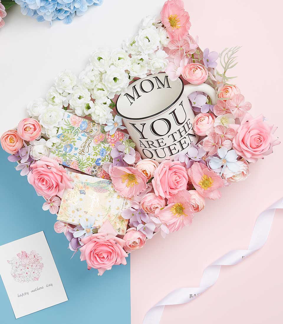 Elegant Mother's Day gift basket with ceramic queen mum mug, pink roses, ranunculus, and greeting card