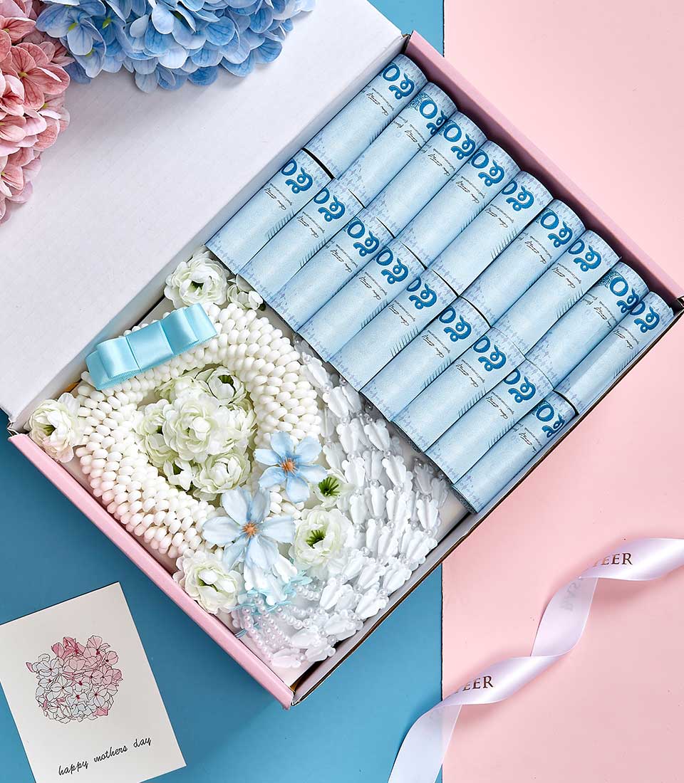Luxury Mother's Day gift basket with rolled blue scrolls, white beaded floral garland, and greeting card