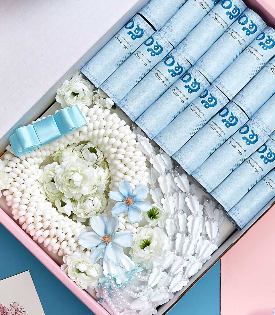 Mother's Day gift basket with white beaded garland, light blue artificial flowers, silk bow, and pearl jewellery in blush box