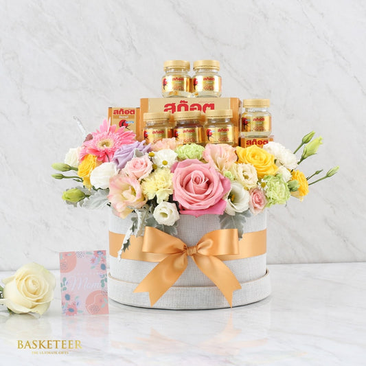 Premium scotch and fresh flower gift box with pink roses, gerbera daisies, and gold-capped bottles for Mother's Day