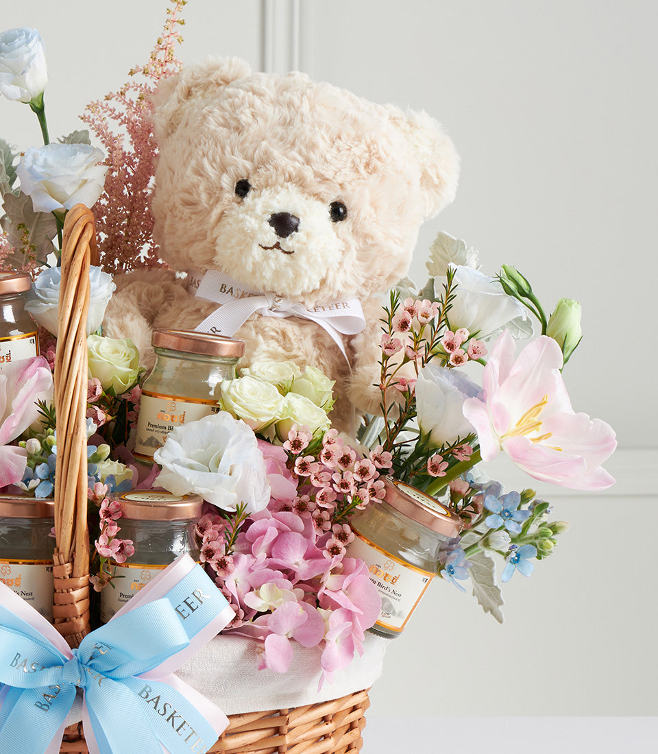 Pastel Mother's Day gift basket with beige teddy bear, bird's nest jars, and fresh roses, hydrangeas, tulips in cream and