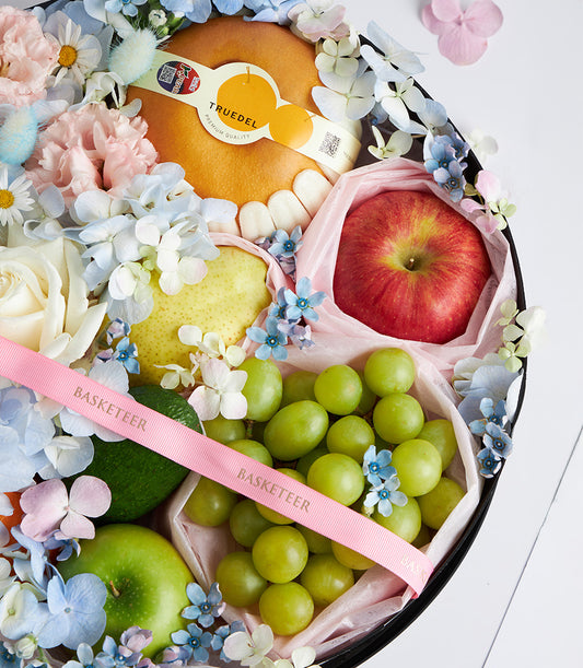 Deluxe Mother's Day fruit and flower gift box with fresh pears, apples, grapes, and premium blooms in white and pale pink
