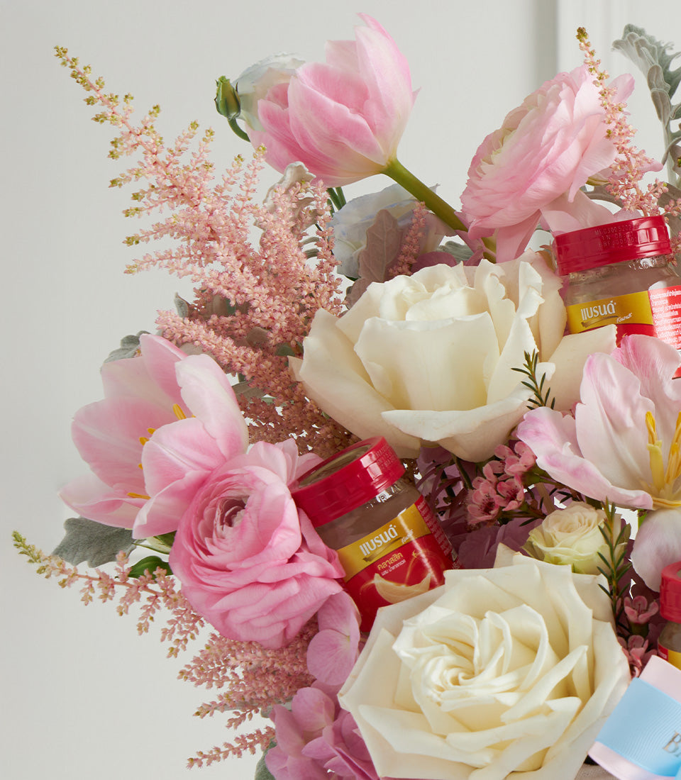 Pink tulips, white roses, and ranunculus with glass jar accents in Mother's Day flower basket