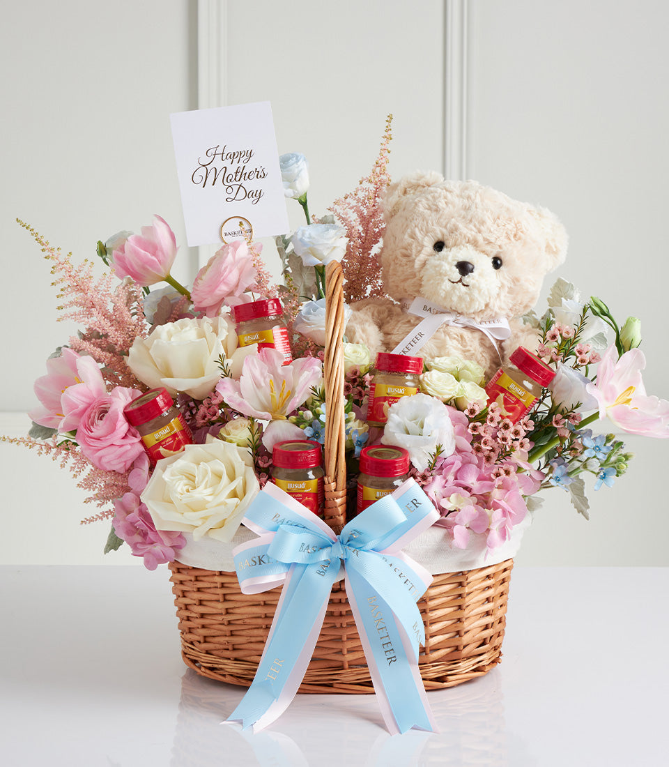 Cream teddy bear with fresh pink and white roses in wicker basket, Mother's Day gift