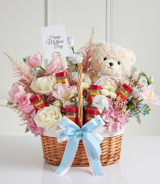 Cream teddy bear with fresh pink and white roses in wicker basket, Mother's Day gift