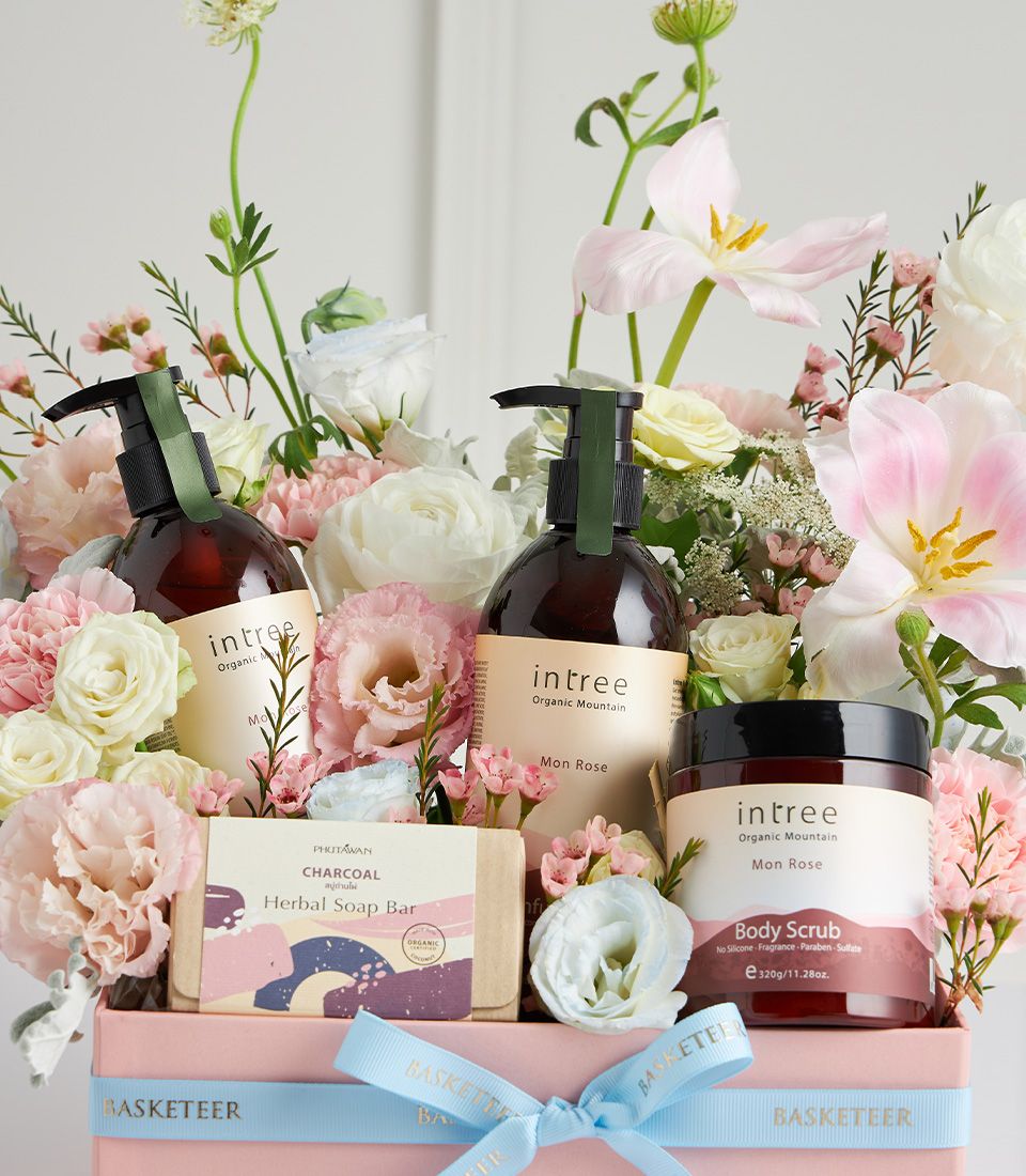 Basketeer premium hamper delivery Thailand: Spa gift box with Intree lotions, body scrub, and floral arrangement, wrapped with a light blue ribbon.