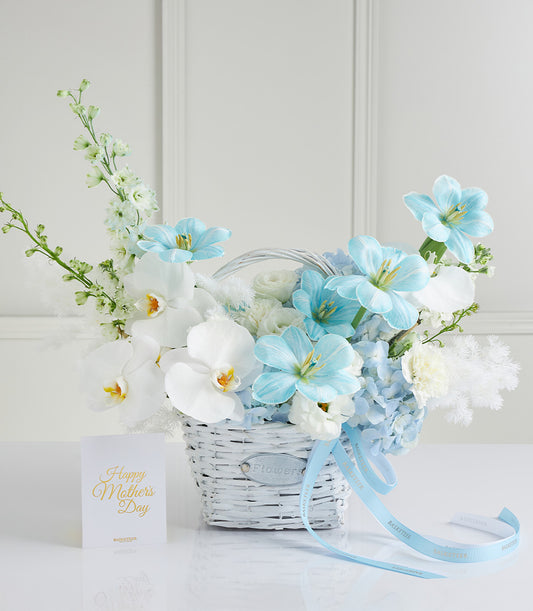 Blue and white floral gift basket with orchids, tulips, delphiniums, and hydrangeas for Mother's Day