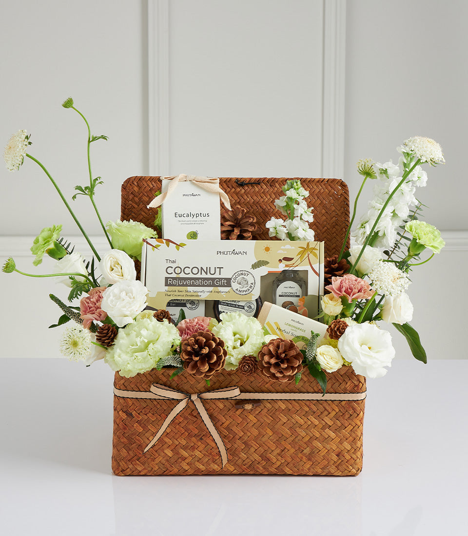 Woven spa gift basket with Thai coconut rejuvenation, eucalyptus, lemongrass soap, and fresh white and pink flowers for