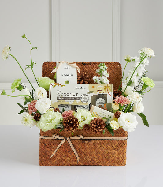 Woven spa gift basket with Thai coconut rejuvenation, eucalyptus, lemongrass soap, and fresh white and pink flowers for