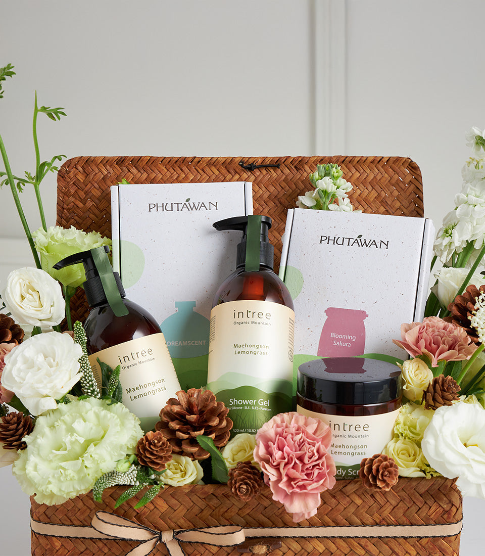 Natural spa and wellness gift basket with organic lemongrass shower gel, body scrub, and floral soaps, adorned with fresh