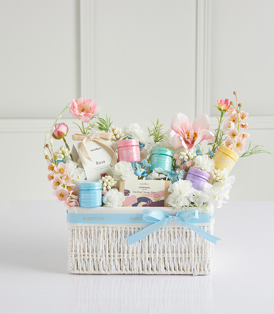 Luxury Mother's Day spa basket with herbal bath products, fresh flowers, and artisan soap in white woven basket