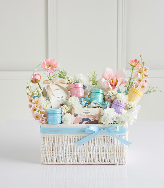 Luxury Mother's Day spa basket with herbal bath products, fresh flowers, and artisan soap in white woven basket