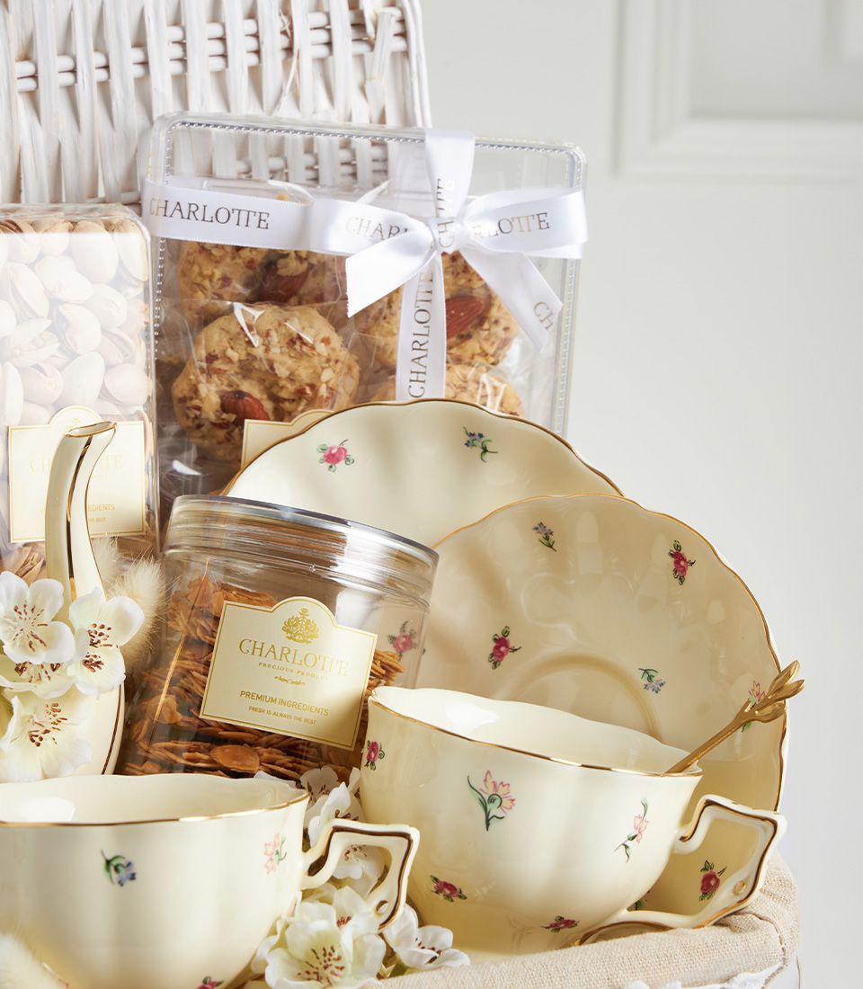 Luxury tea set with gourmet cookies and granola in cream floral teacups, artisan Mother's Day gift basket