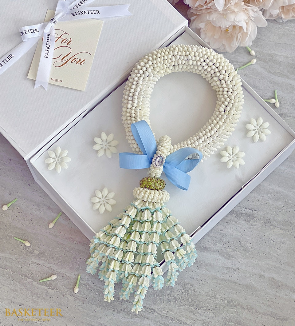 Luxurious white jasmine phuang malai garland in gift box with blue-accented tassel pendant, Mother's Day gift
