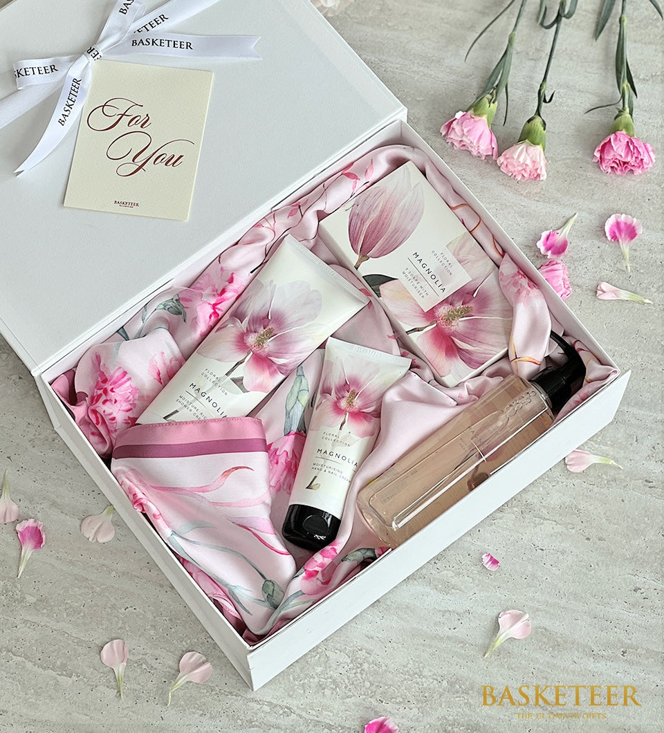 Luxury spa gift set with pink silk scarf, magnolia creams, and soap in white box with carnations