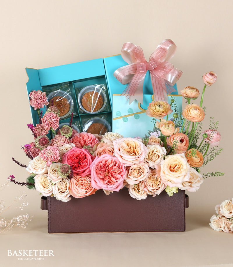 Luxury mooncake gift box with pink and peach roses, carnations, and ranunculus in leather container