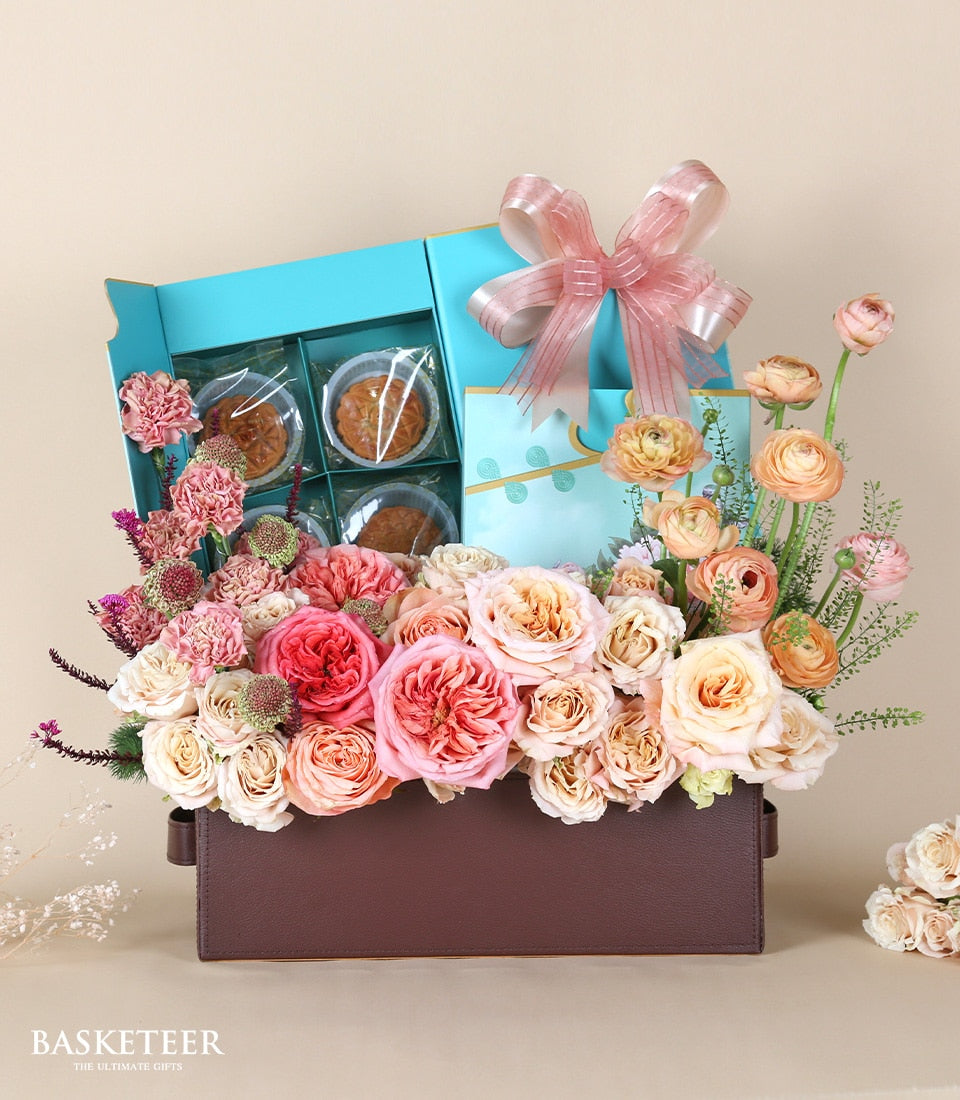 Luxury mooncake gift box with pink and peach roses, carnations, and ranunculus in leather container