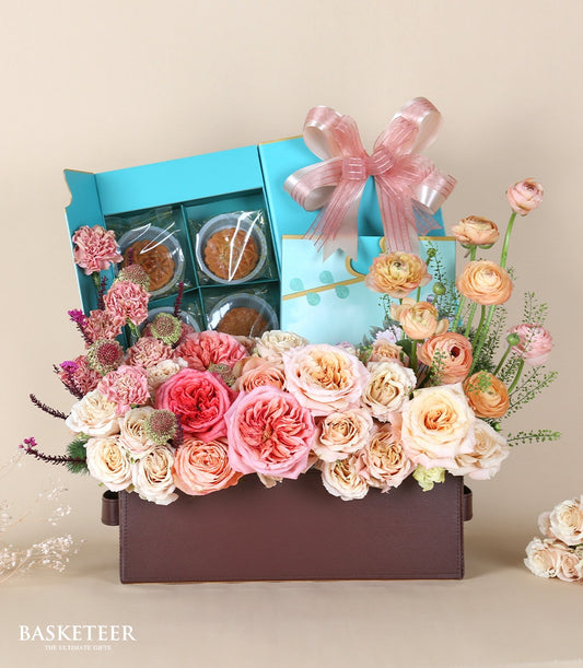 Luxury mooncake gift box with pink and peach roses, carnations, and ranunculus in leather container
