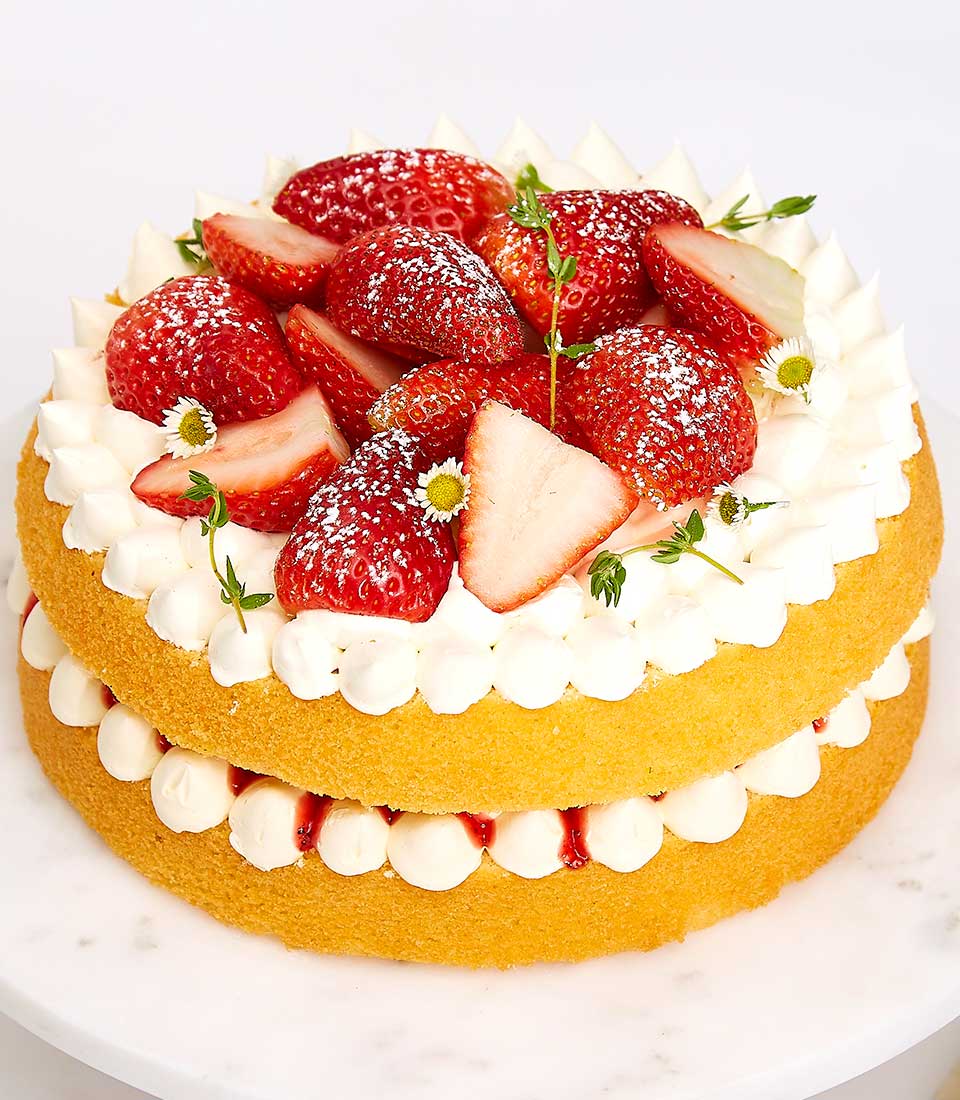 Summery strawberry cream layer cake with fresh berries and whipped cream, artisan birthday celebration