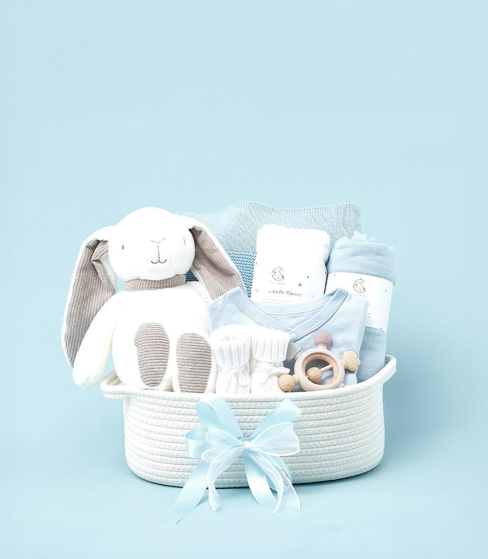 Blue baby boy gift basket with plush bunny, knitted blanket, onesie, and wooden rattle