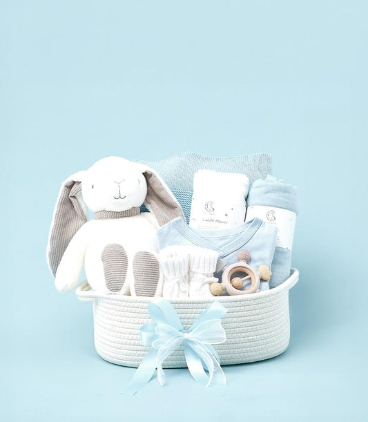 Blue baby boy gift basket with plush bunny, knitted blanket, onesie, and wooden rattle