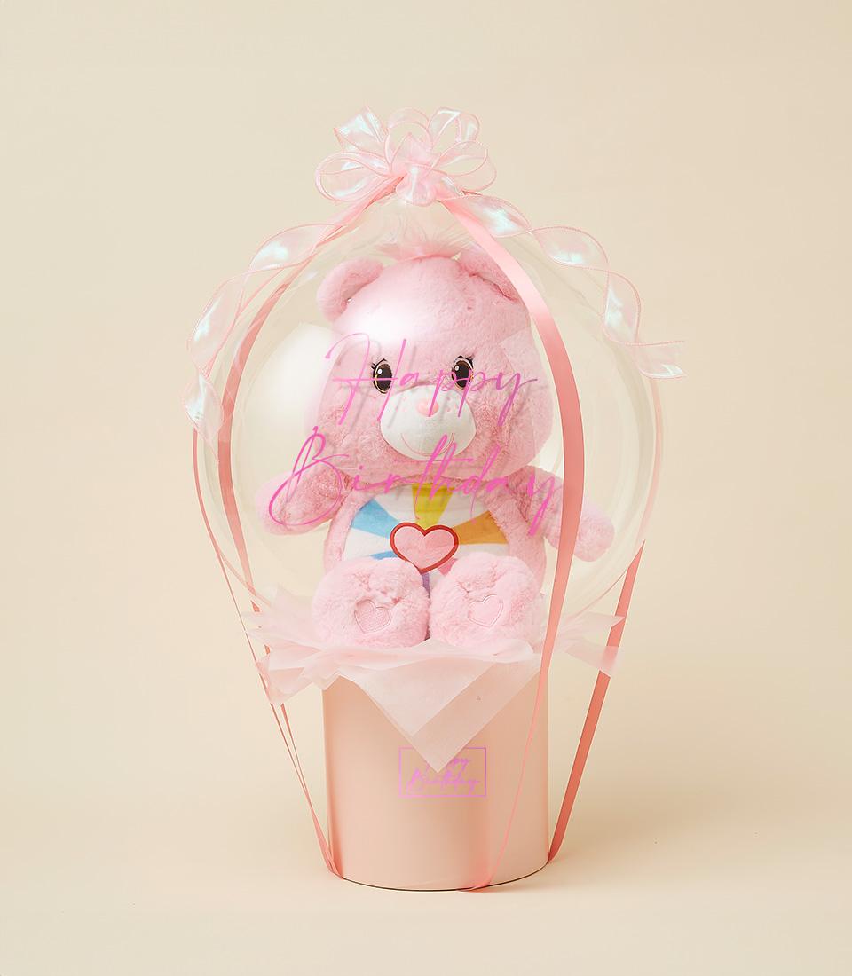 Pink Care Bear plush toy in clear balloon container with pink ribbons and tulle, birthday gift for kids