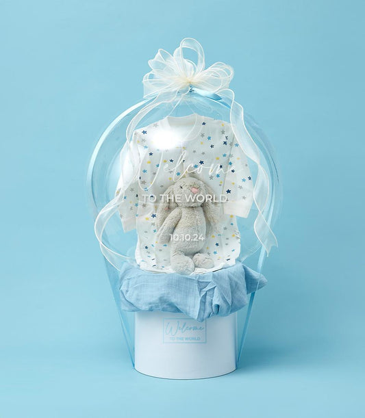 Baby boy gift hamper with white star romper and plush bunny in balloon-shaped container