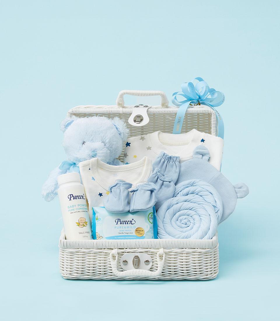 Light blue and white baby gift basket with teddy bear, star bodysuits, mittens, blanket and Pureen essentials