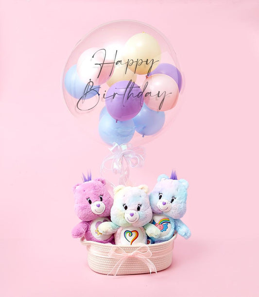 Pastel Care Bears plush toys in woven basket with Happy Birthday balloon and pink ribbon bow, kids birthday gift hamper