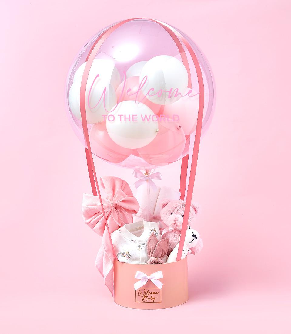 Welcome Baby Girl hot air balloon gift set with plush teddy, onesie, and accessories in pink and white