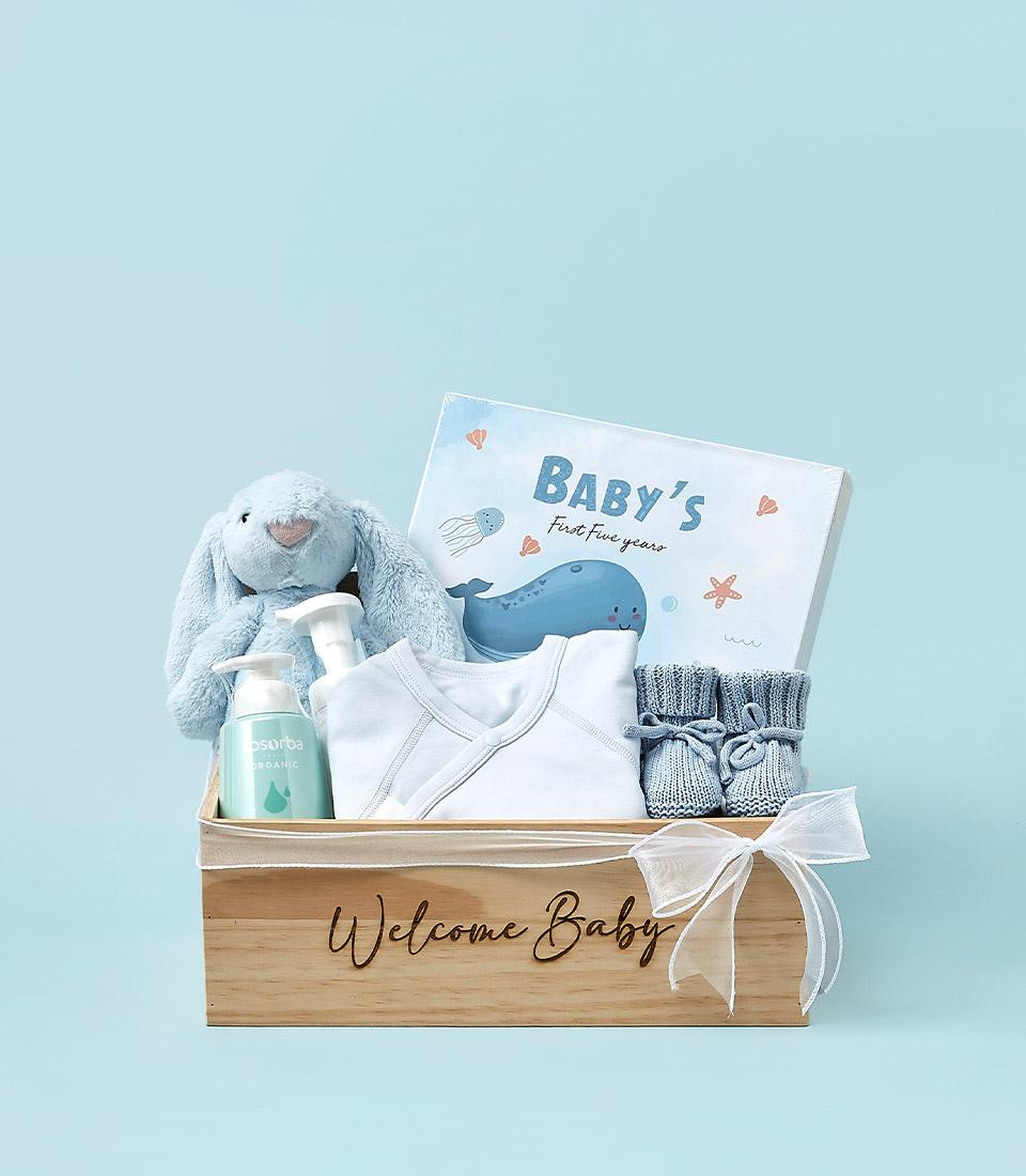 Wooden newborn gift set with white bodysuit, blue bunny, organic lotion, booties and memory book in "Welcome Baby" box